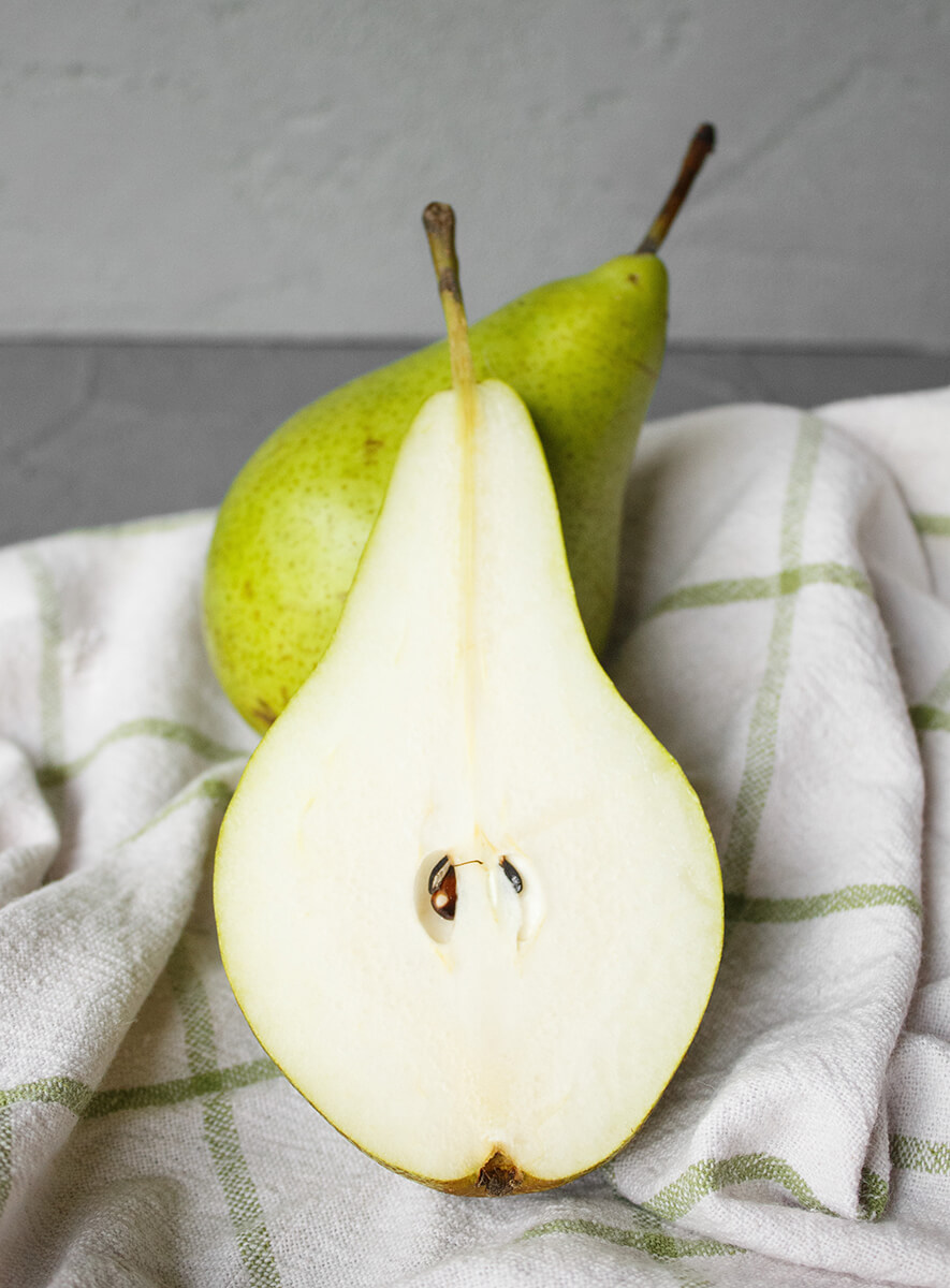Colores y propiedades de las frutas y verduras. Pera cortada por la mitad, fruta de color blanco